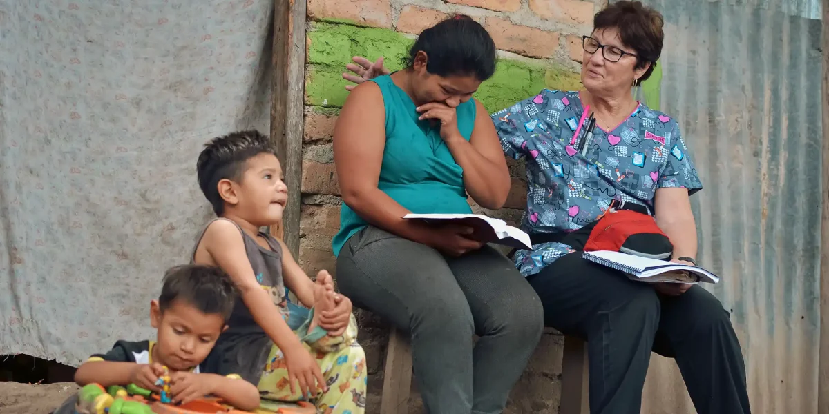 Missionary woman studying scripture with Honduran woman and children