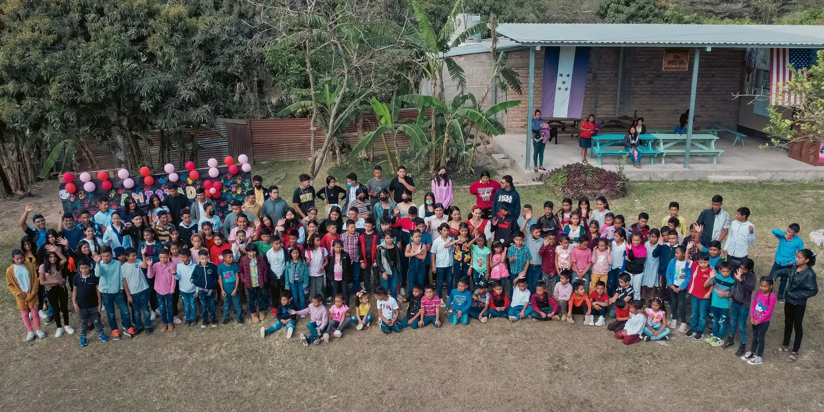 large gathering of school children outside the school house