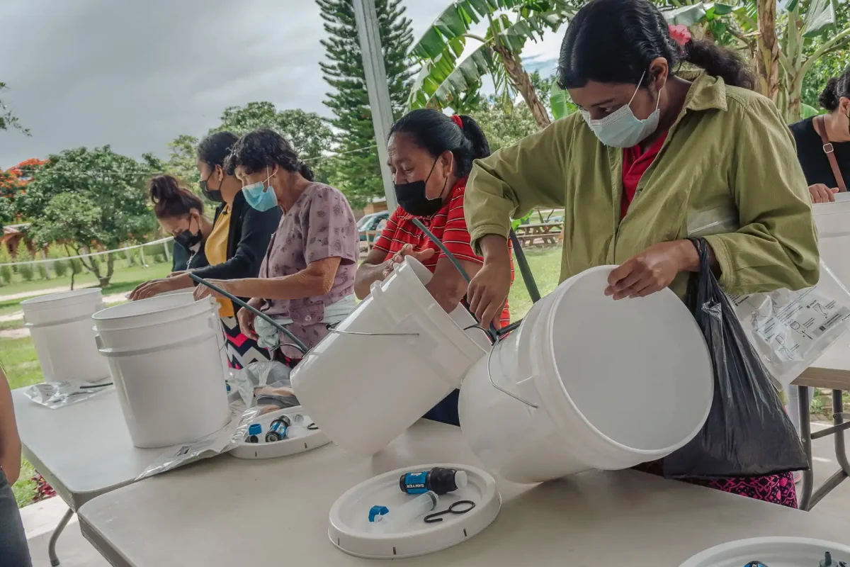 table with clean water kits, people inspecting them