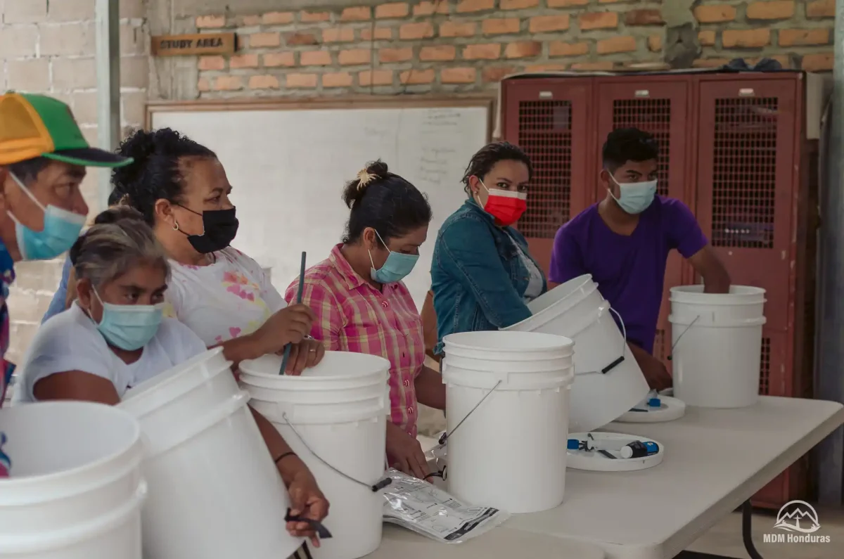 several people hands-on with water buckets