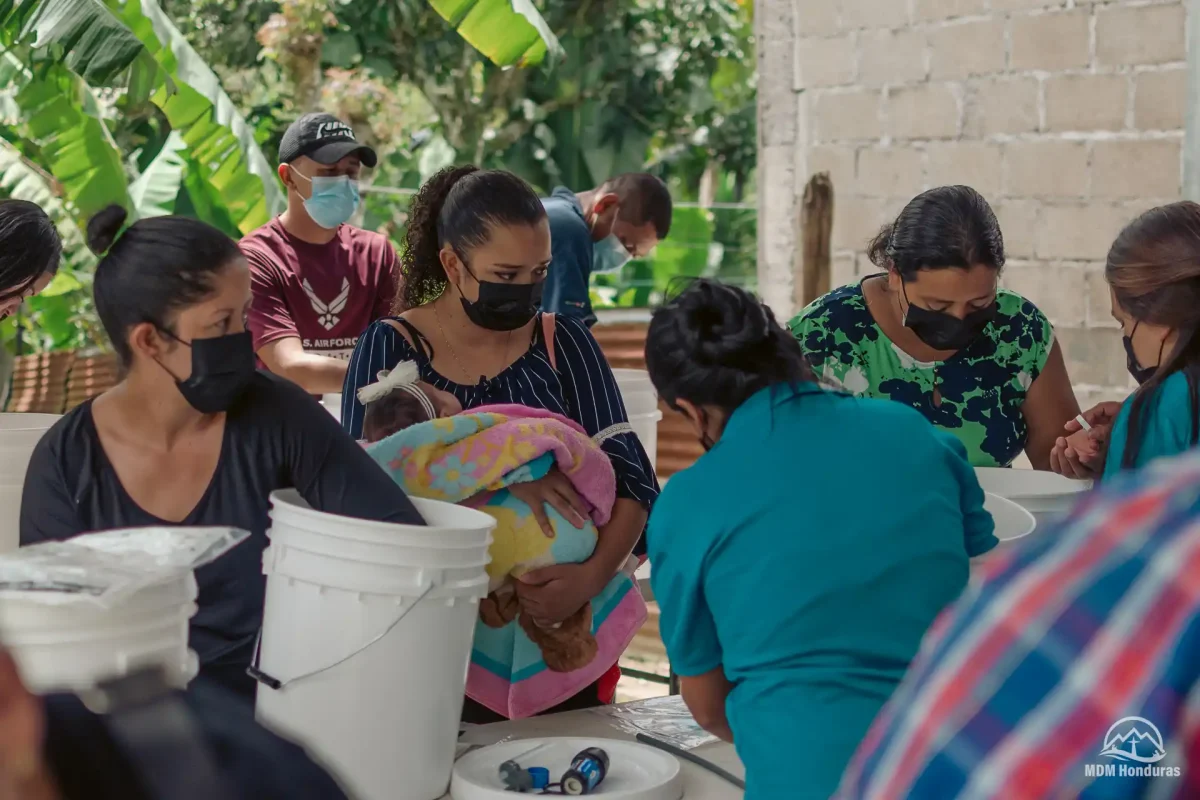 group of people working with their water filtration buckets