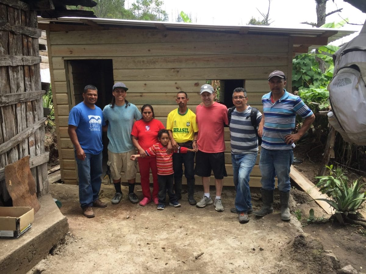 Mission team members and family outside village house