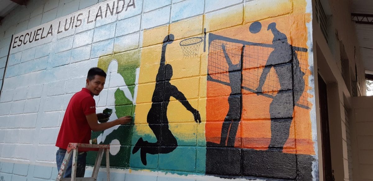 Joel Valle painting a mural