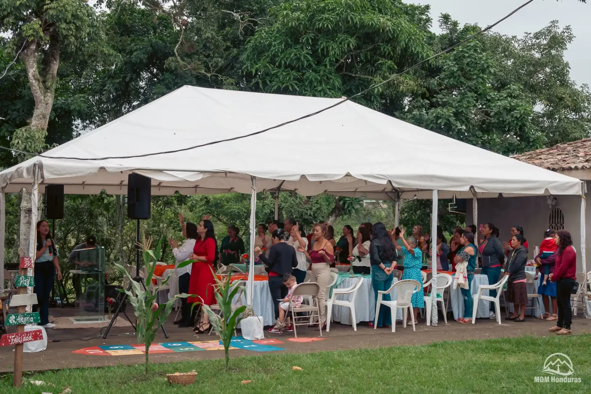 group of women in worship under large tent