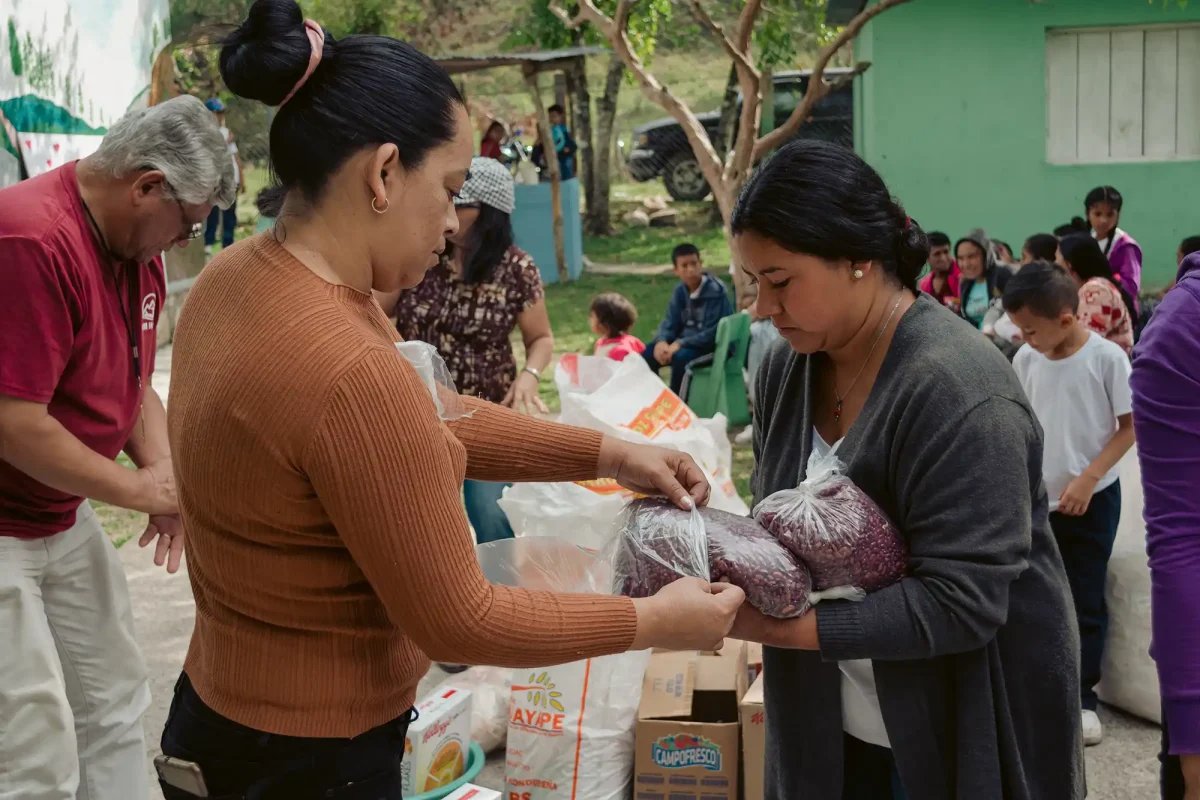 Woman receiving bags of beans at food distribution