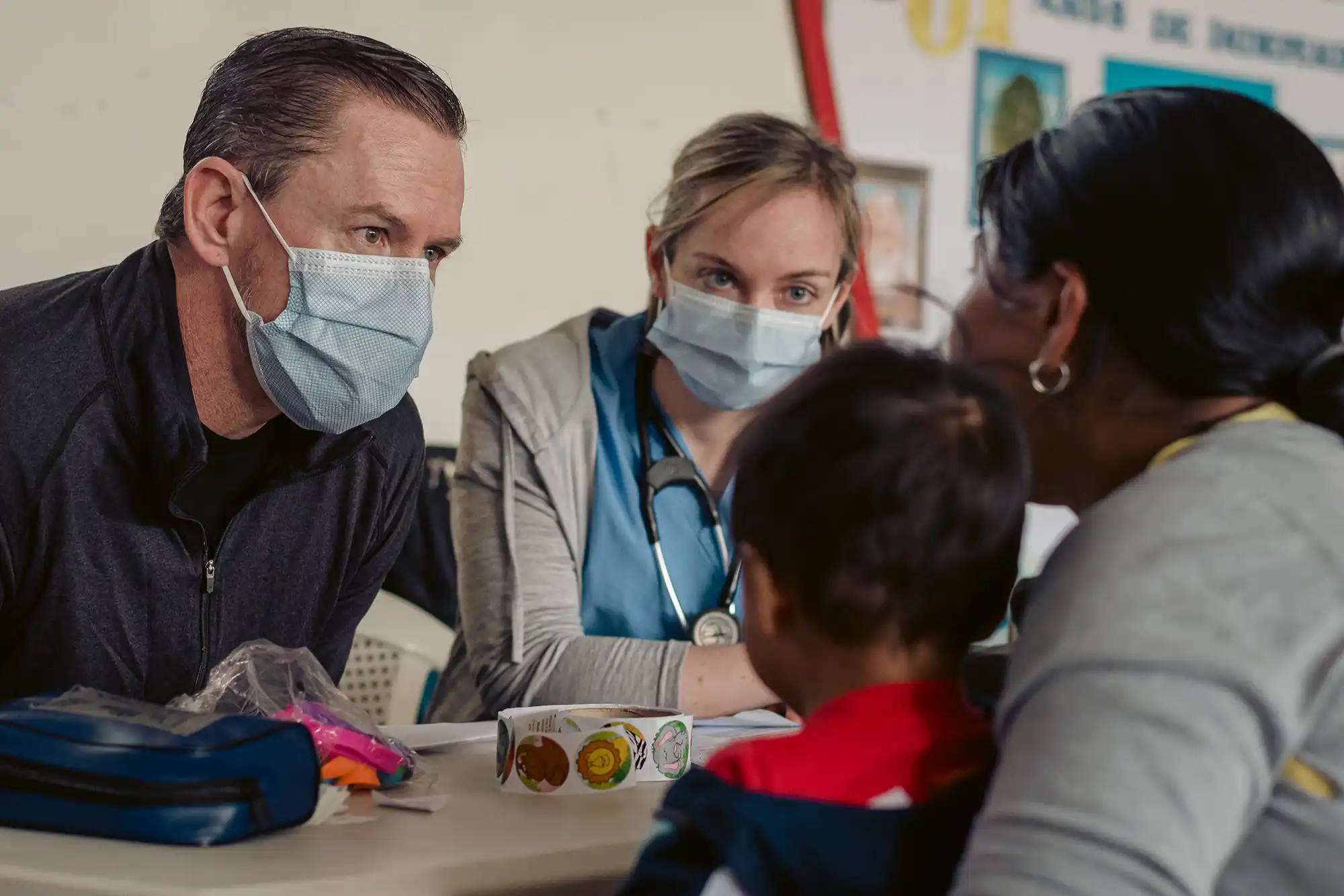 mother with child in consultation with health care workers