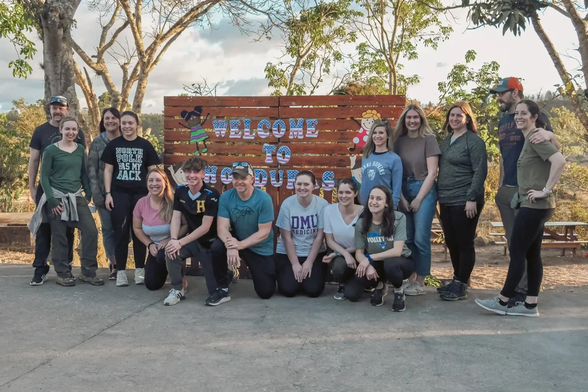 mission trip team posing in front of Honduras sign