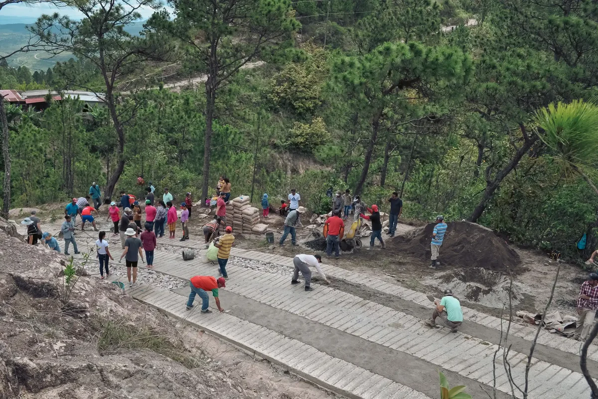 mission team and community members building a road up the hill