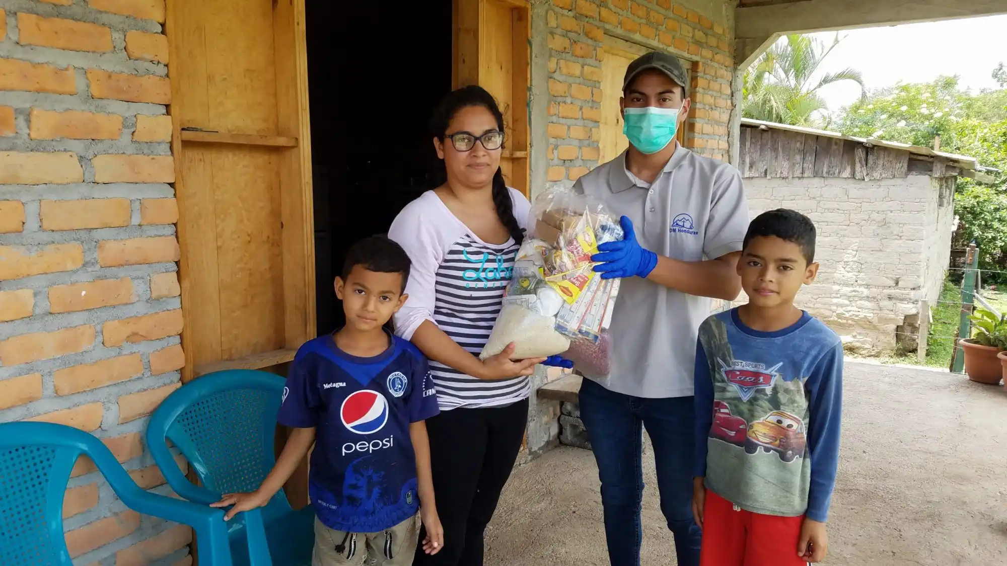 Mother and 2 children receiving bag of food items