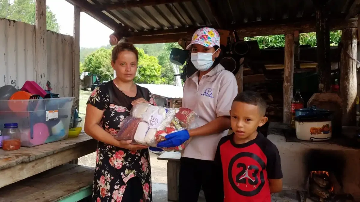 Mother and boy receiving bag of food items