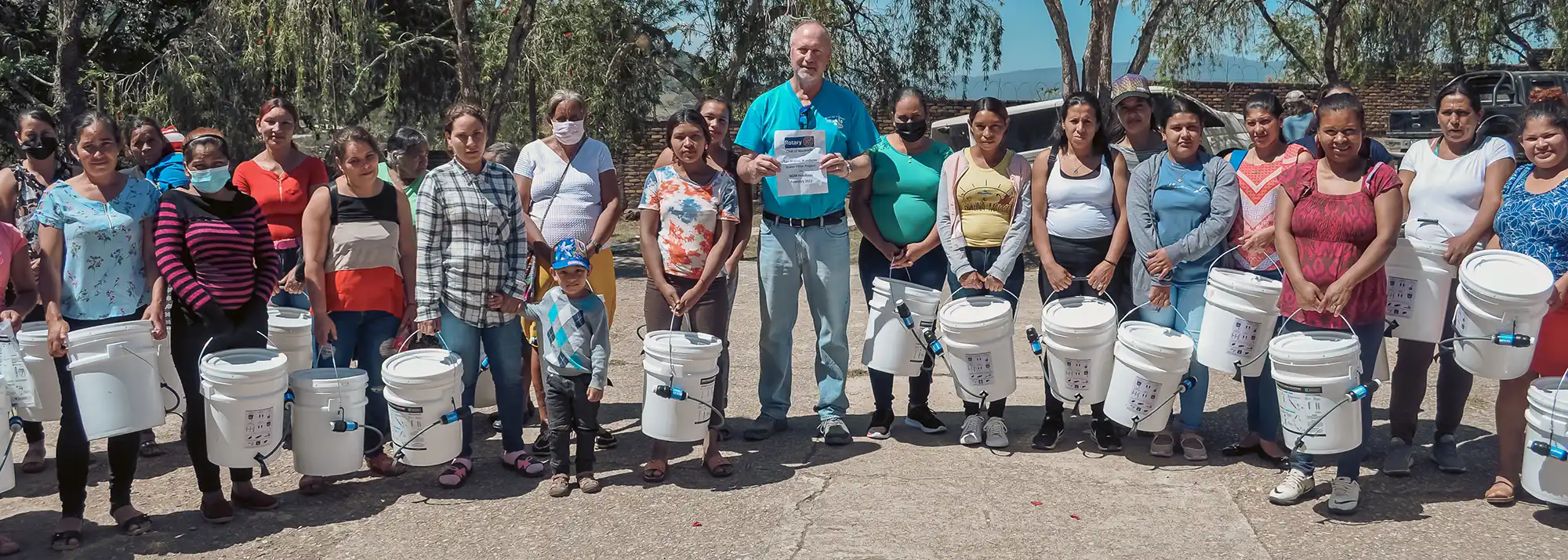 large group of villagers who have received water filtration equipment